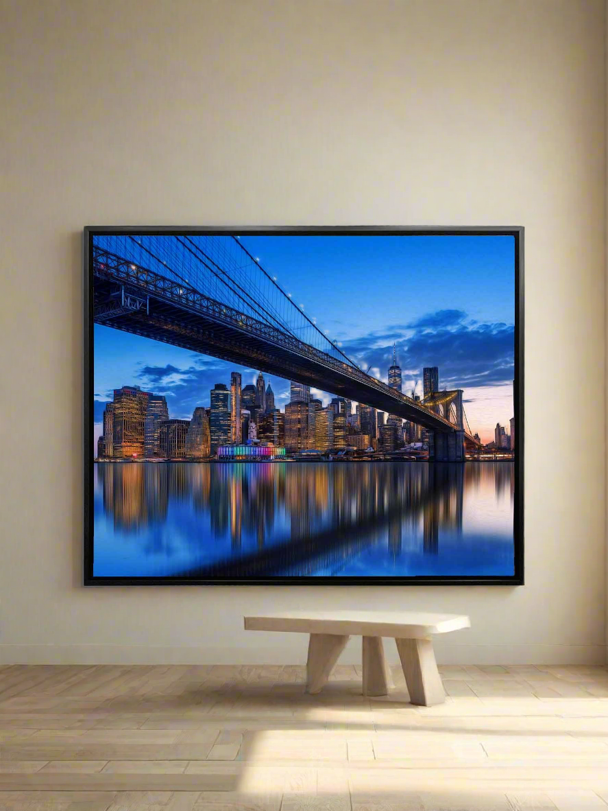 Large wall art displaying a cityscape with a bridge, mounted on a wall above a table.