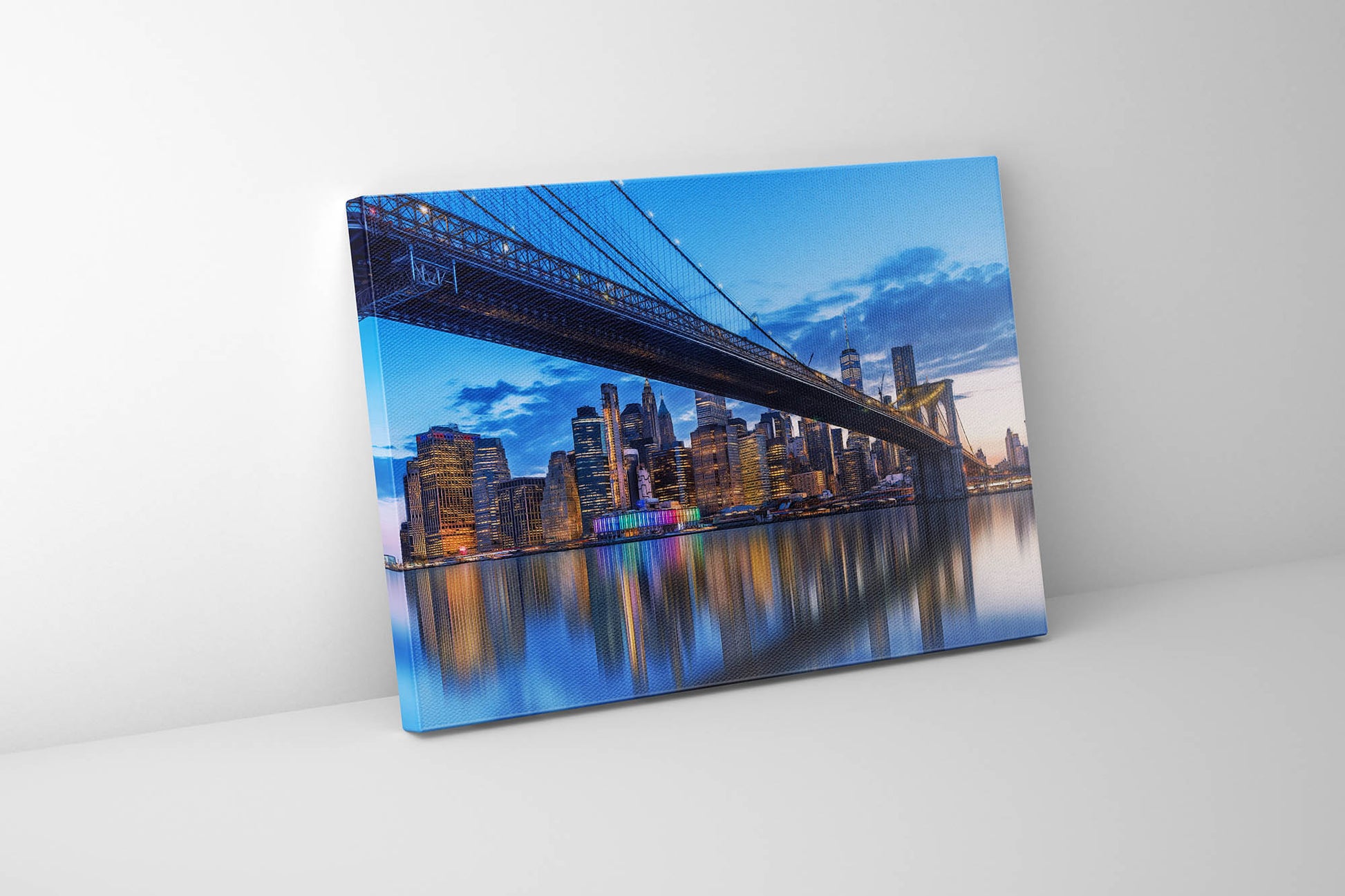 A canvas print depicting the New York City skyline with the Brooklyn Bridge and Manhattan Bridge over the East River, featuring an RGB finish.