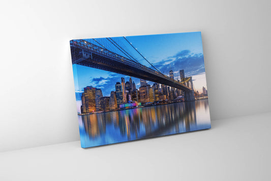 A canvas print depicting the New York City skyline with the Brooklyn Bridge and Manhattan Bridge over the East River, featuring an RGB finish.